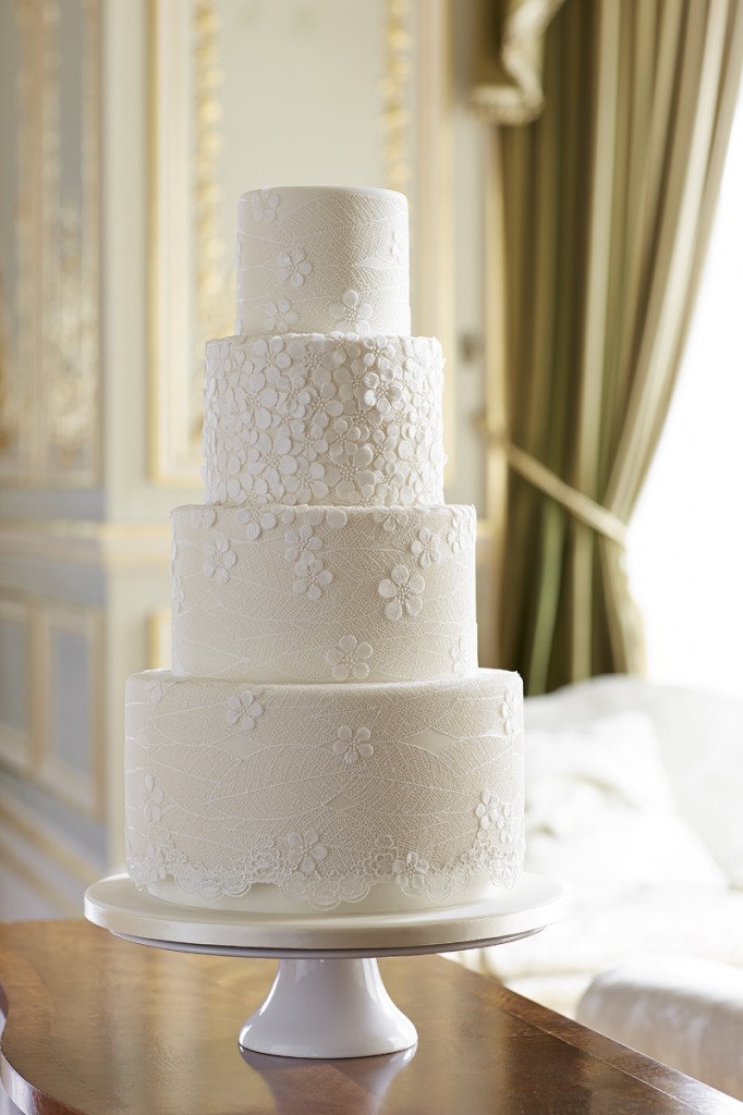 wedding cake with blossom appliqués and cake lace